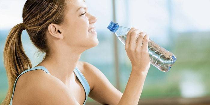 Ragazza con una bottiglia di acqua minerale