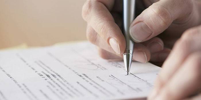 Mannen signerer en kontrakt