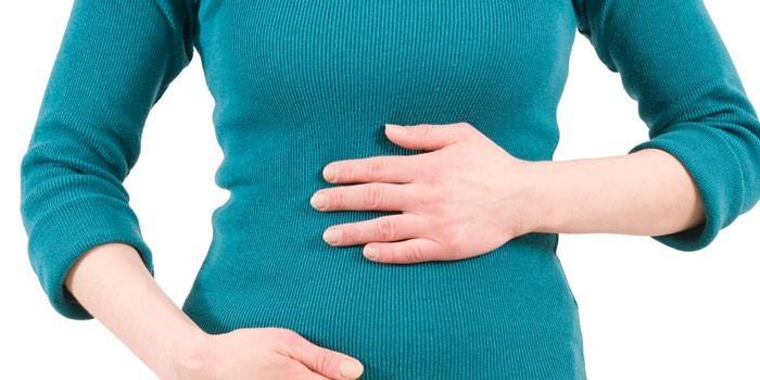 Mujer sostiene sus manos sobre su estómago