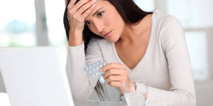 Chica con paquete de pastillas en la mano