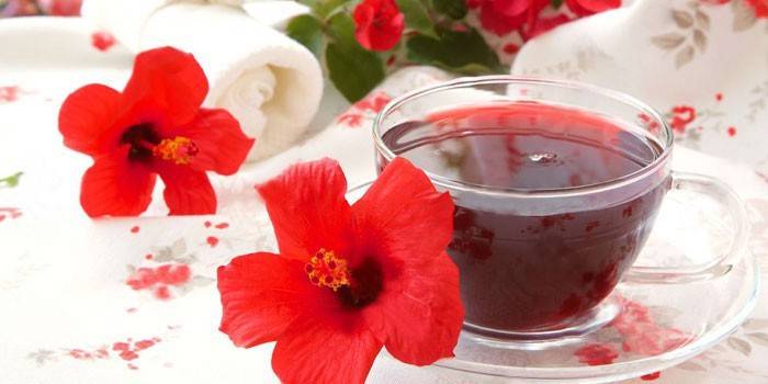 Hibiska tēja krūzē un hibiska ziedi