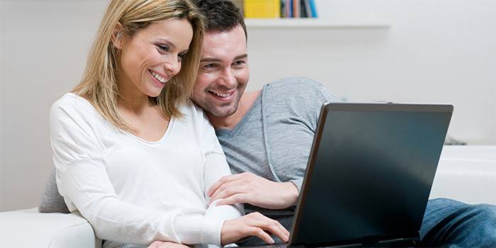 Le gars et la fille regardent l'ordinateur portable