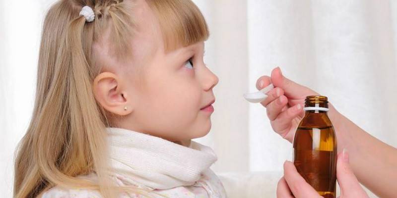 La niña recibe jarabe
