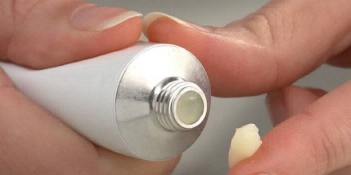 Tube avec pommade dans les mains