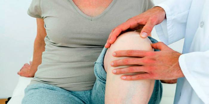 Le médecin examine le genou du patient