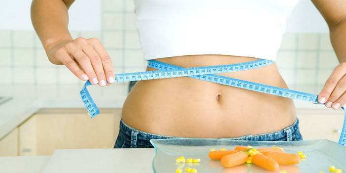 La ragazza misura la vita con un centimetro