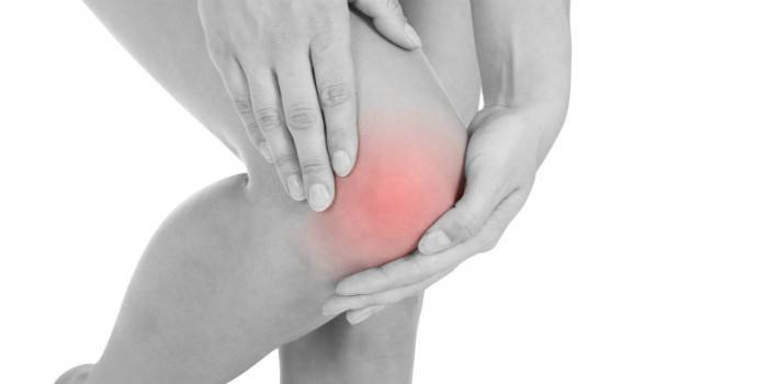 Mädchen hält sich an einem wunden Knie fest