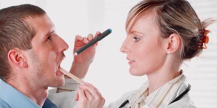 Il medico esamina la gola del paziente