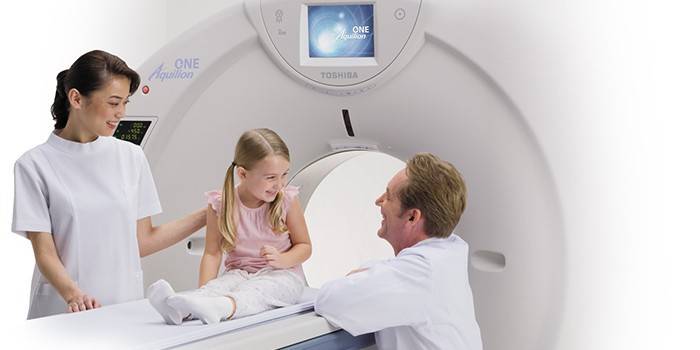 Médicos e uma garota em uma máquina de ressonância magnética