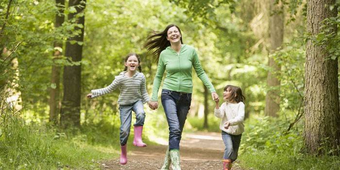Femme avec des enfants pour une promenade dans la forêt