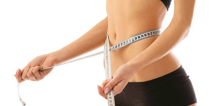 La ragazza misura il volume della vita con un centimetro