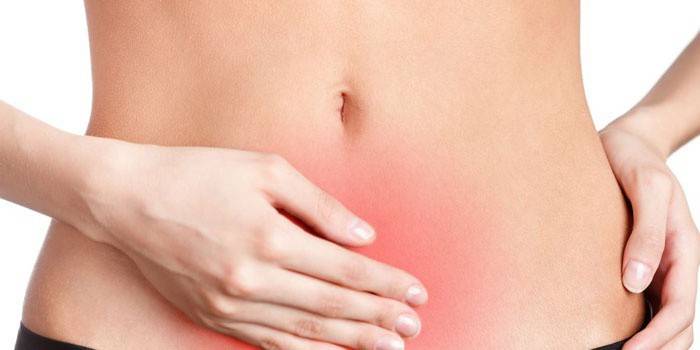 La donna tiene la mano nell'addome inferiore