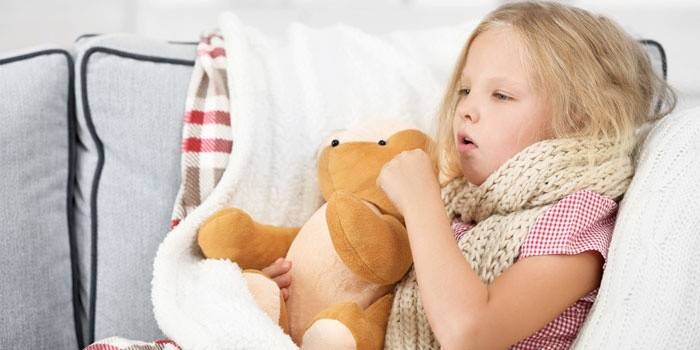 Ragazza seduta nel letto e tosse