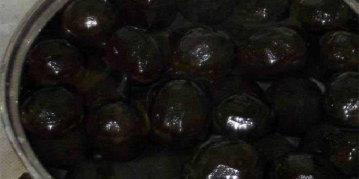 Giovani noci verdi in una padella con sciroppo
