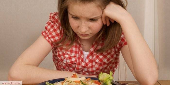 Fille regardant une assiette de nourriture