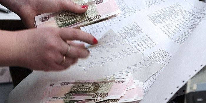 Χρήματα στα χέρια στο φόντο των λιστών