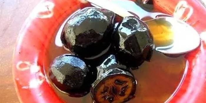 Le giovani noci si inceppano su un piatto con un cucchiaio