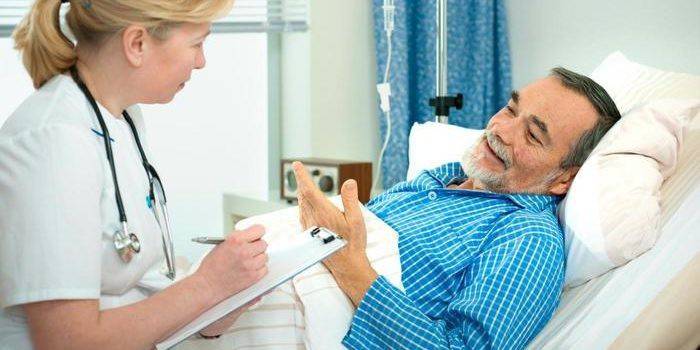 Un bărbat dintr-un cabinet de spital vorbește cu un medic