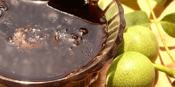 Giovani noci e vaso con marmellata di noci