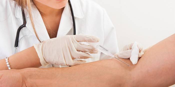 Medic dă o injecție intravenoasă unui om
