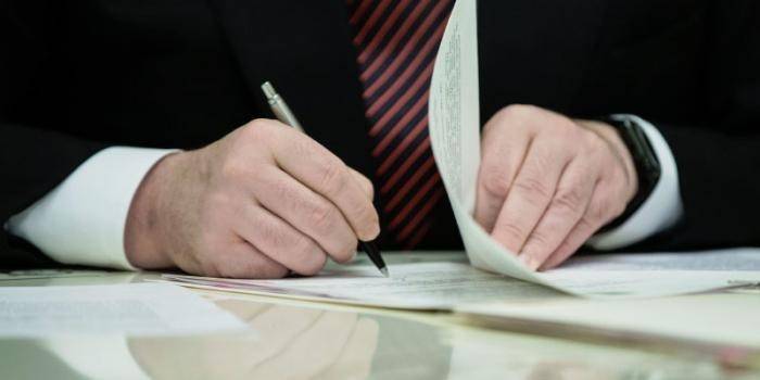 Mannen signerer dokumenter