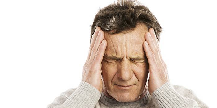 Một người đàn ông giữ đầu bằng hai tay.