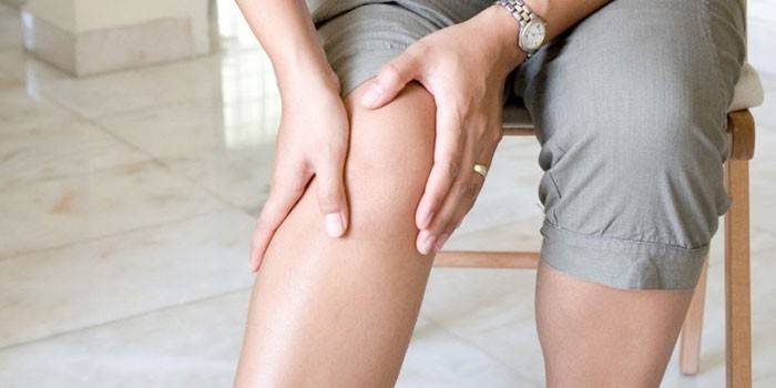 Người phụ nữ nắm tay trên đầu gối