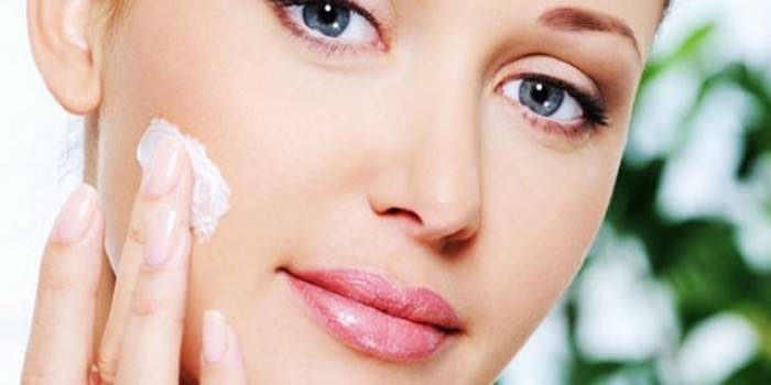 Fille met la crème sur son visage
