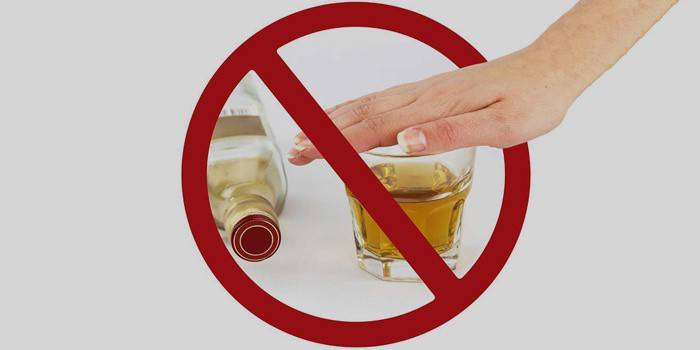 Perbrauktas butelis ir stiklinė su alkoholiu