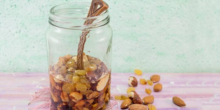 Cuchara en un tarro de miel y nueces.