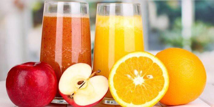 Manzanas, naranjas y dos vasos de jugo.