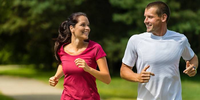 El chico con la chica corriendo en el parque