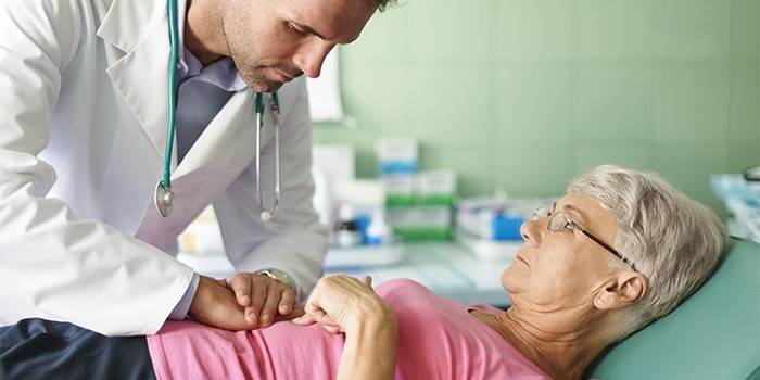 Il medico palpa l'addome di una donna