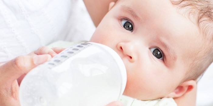 Baby spiser en blanding fra en flaske