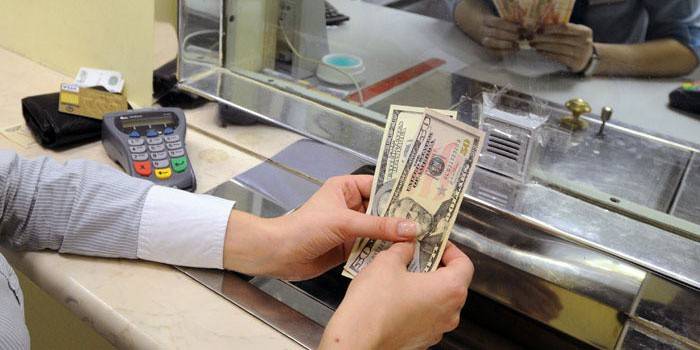 فتاة مع المال في نافذة شباك التذاكر.