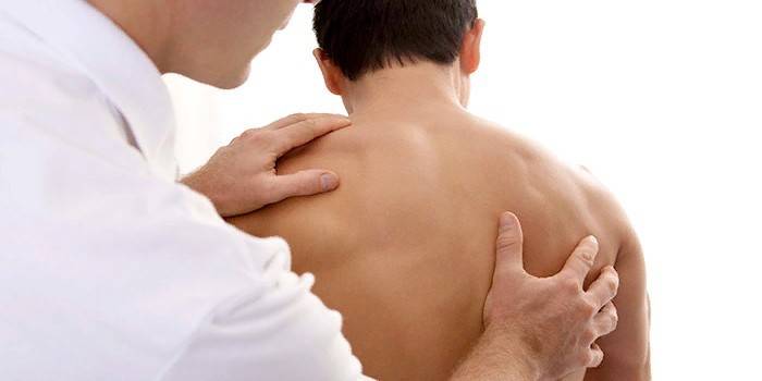Il medico esamina la pelle sul retro del paziente