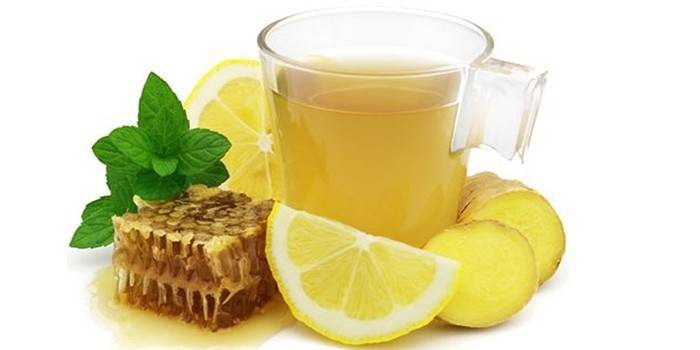 Puodelis su gėrimu ir ingredientais.