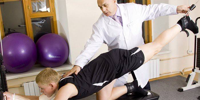 Medicul efectuează exerciții terapeutice cu pacientul