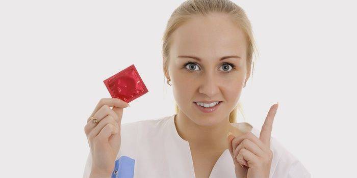 Medico con un preservativo in mano
