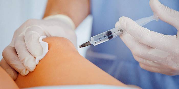 Medic face o injecție intraarticulară a medicamentului
