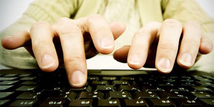 Fingrene til en mann over et datatastatur