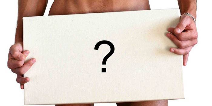 Un hombre sostiene un cartel con un signo de interrogación delante de él.