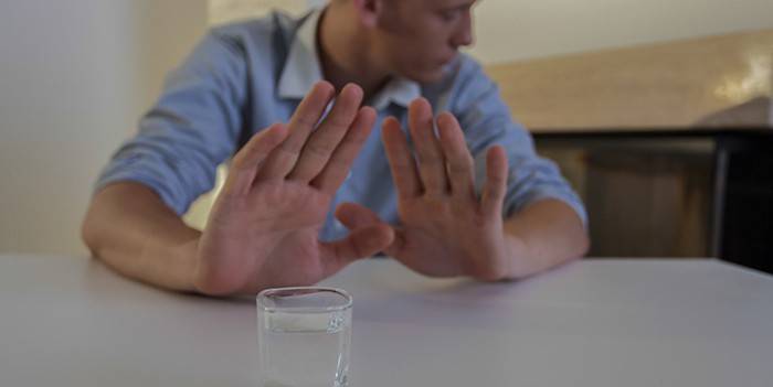 Un uomo rifiuta un bicchiere di vodka
