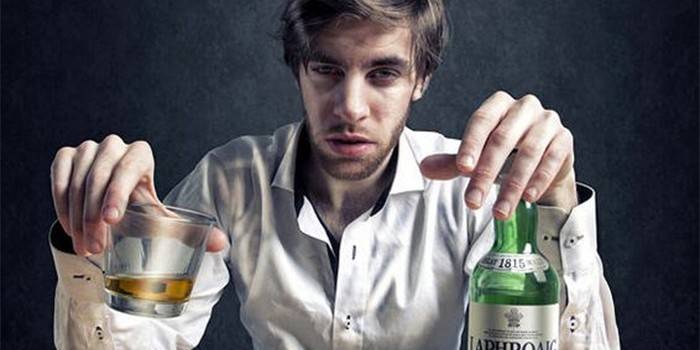 Człowiek z butelką i kieliszkiem alkoholu