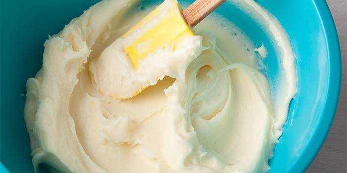 Queso crema en un bol y espátula