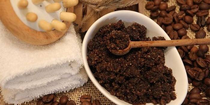 Gommage au café dans un bol et une brosse de massage