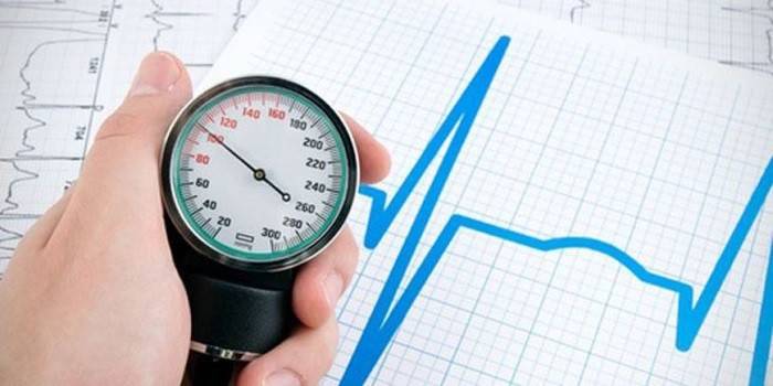 Tonometro in mano e grafico della frequenza cardiaca