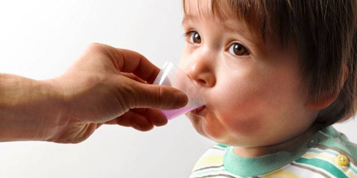 Al bambino viene somministrata la medicina in un misurino