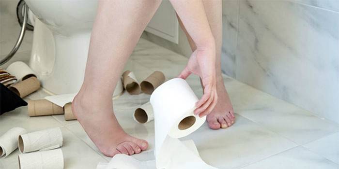 Ragazza sul water e rotolo di carta igienica