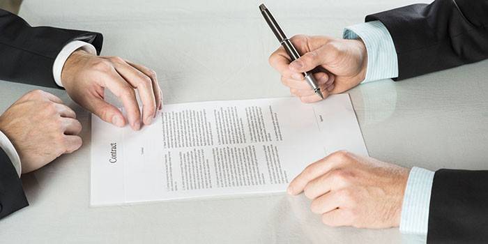 Menn signerer en kontrakt